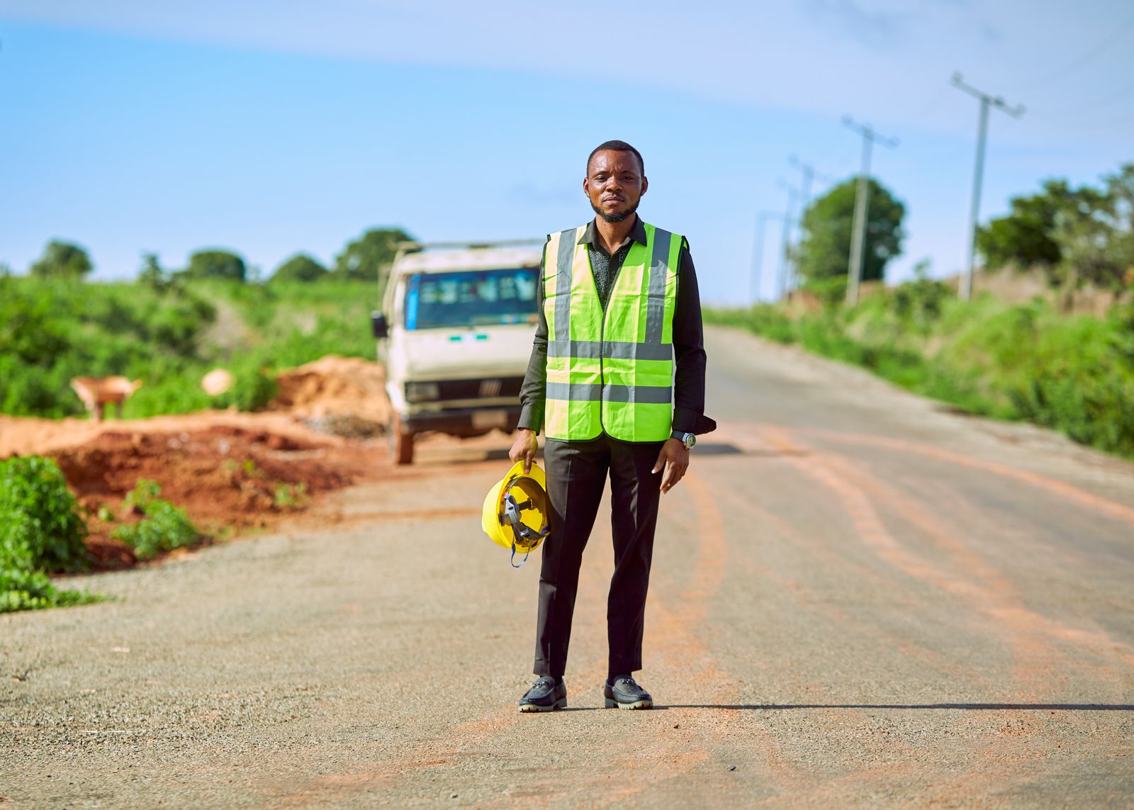 Agent en équipement haute visibilité sur une piste, en contexte ouest-africain